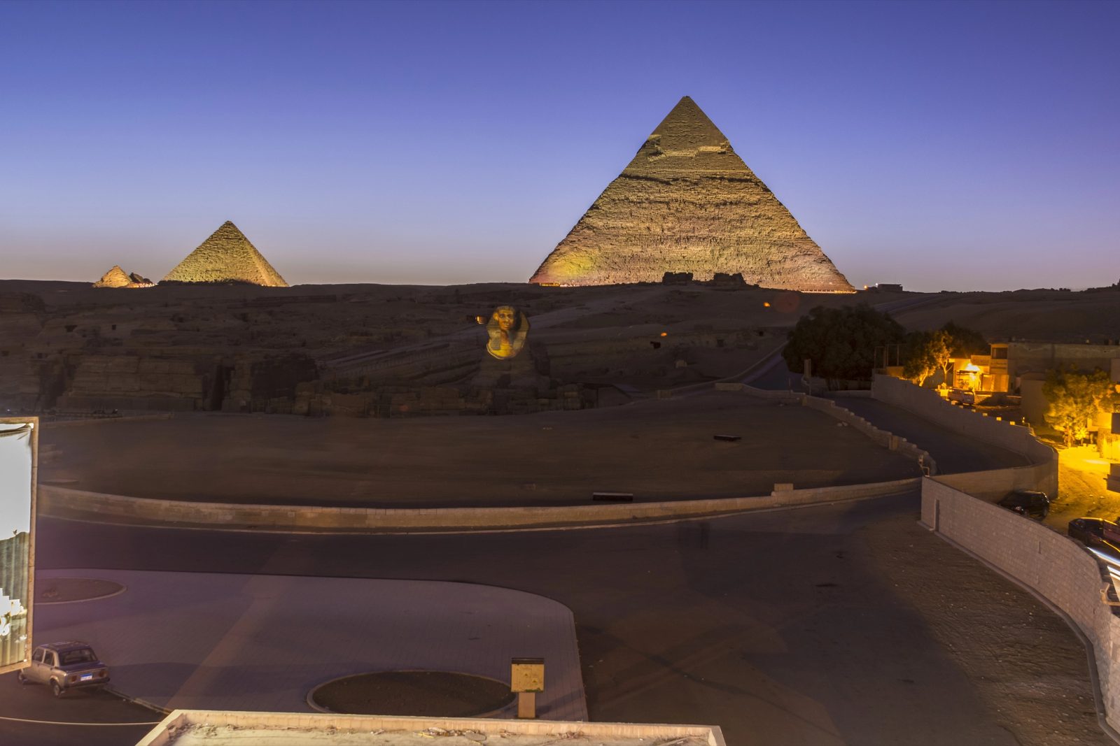 The pyramids of Giza glowing over the desert at dusk