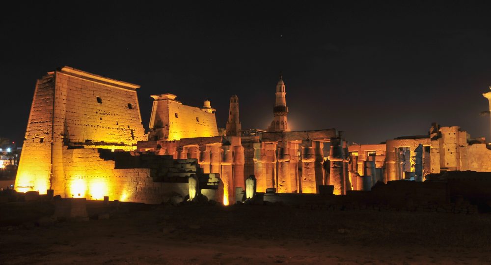 Luxor Temple illuminated at night beside the Nile